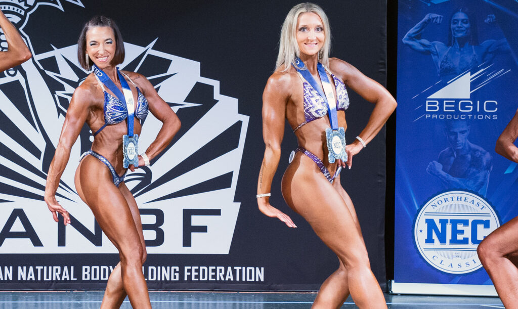 Natural female athlete showcasing muscularity and conditioning during ANBF FemFit competition